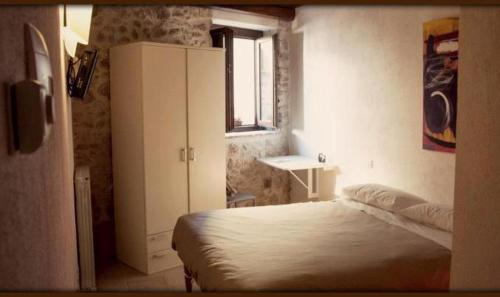 a bedroom with a bed and a cabinet and a window at Le Pagliare Del Gran Sasso in Assergi