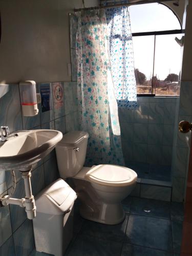 a bathroom with a toilet and a sink and a shower at Hostal Campestre Casa Blanca in Chucuito
