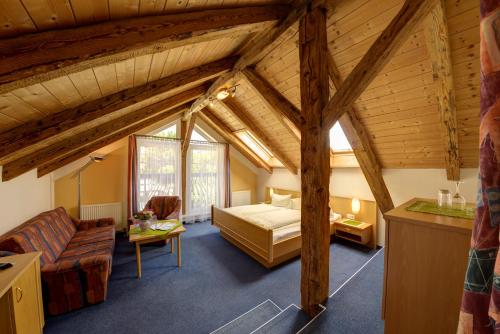 ein Schlafzimmer mit einem Bett und einem Sofa in einem Zimmer in der Unterkunft Hotel Flattacher Hof in Flattach