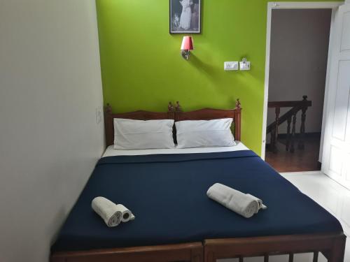 a bedroom with a bed with two towels on it at seaway's inn in Cochin