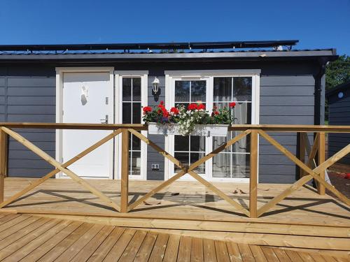 eine Veranda eines Hauses mit einer weißen Tür und Blumen in der Unterkunft Rasta Götene in Götene