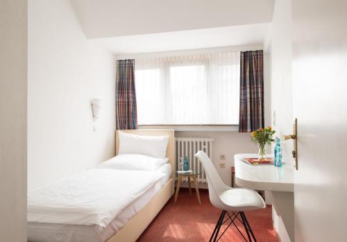 a hotel room with a bed and a desk at Hotel Feldmann in Münster
