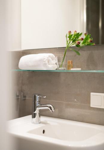 a bathroom with a sink and a mirror and towels at Hotel Feldmann in Münster