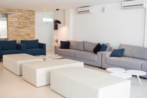 a living room with couches and tables at Wave Suítes Hotel & Lounge bar in Maceió