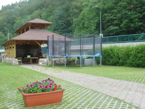a garden with a gazebo and flowers in a pot at Penzion Měšťanský Dům in Svoboda nad Úpou