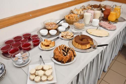 a table topped with different types of cakes and pastries at Hotel Tres Cruces in Montevideo