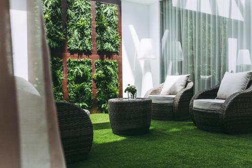 a group of wicker chairs sitting on a lawn at Masa Hotel 5 de Outubro in Lisbon