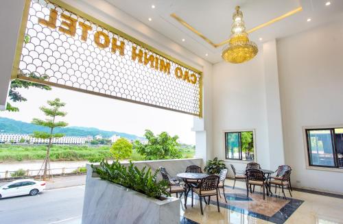 a restaurant with a table and chairs and a large window at Cao Minh Hotel in Lao Cai