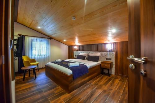 a bedroom with a bed and a wooden ceiling at VADİ UZUNGÖL in Uzungol