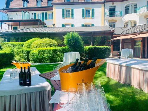 a table with wine bottles and glasses on it at Hôtel la Prairie in Yverdon-les-Bains