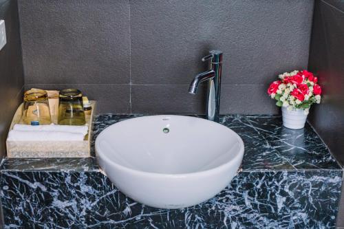 a bathroom with a white sink and flowers on a counter at Cao Minh Hotel in Lao Cai