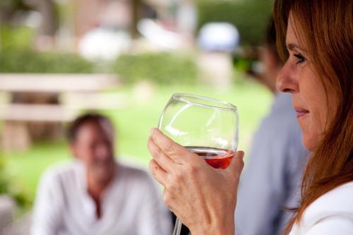 a woman holding a glass of red wine at De Slaapfabriek vakantiehuis en trainingslocatie in Teuge