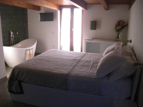 a bedroom with a bed and a bath tub and a tub at B&B Radici24 in Battipaglia