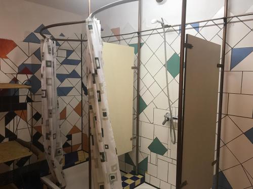 a shower in a bathroom with colorful tiles at Schiff Bihlerdorf - Hostel in Bihlerdorf
