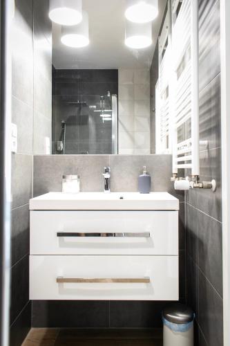 a bathroom with a white sink and a mirror at Dream LUX Apartments in Krakow