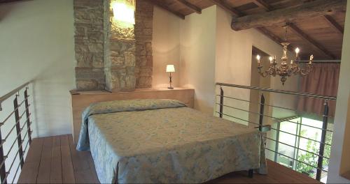 a bedroom with a bed and a chandelier at I Casali del Trebbiolo in Molino del Piano