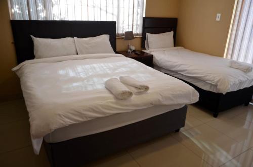 two beds in a bedroom with towels on them at ST@Y-1-BnB in Cape Town