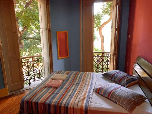 uma cama num quarto com uma grande janela em Massape Rio Hostel no Rio de Janeiro
