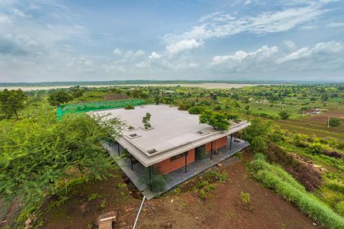 an overhead view of a house on a hill at SaffronStays Zen, Igatpuri - lake-view villa with indoor and outdoor games in Igatpuri
