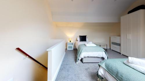 a small bedroom with two beds and a bedskirts at StayZo Westminster Stylish House Accommodation in Bradford