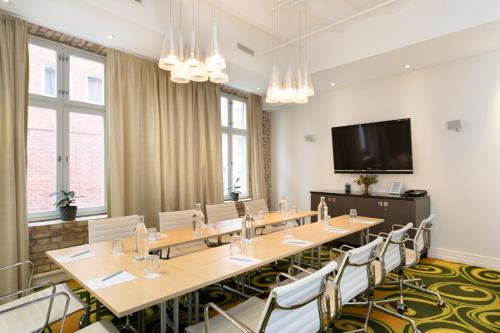 a conference room with tables and chairs and a flat screen tv at Elite Hotel Esplanade in Malmö