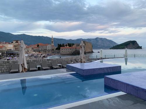 a swimming pool with umbrellas and a view of a city at Avala Resort & Villas in Budva
