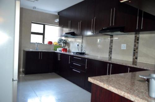a kitchen with dark wood cabinets and a counter top at ST@Y-1-BnB in Cape Town