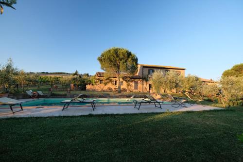 a group of benches sitting next to a pool at Agriturismo Santa Maria in Pienza