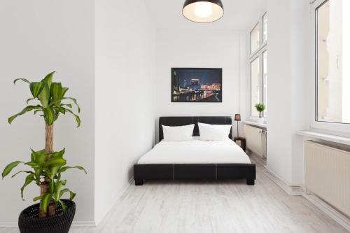 une chambre avec un lit et une plante en pot dans l'établissement The Cloud, à Berlin