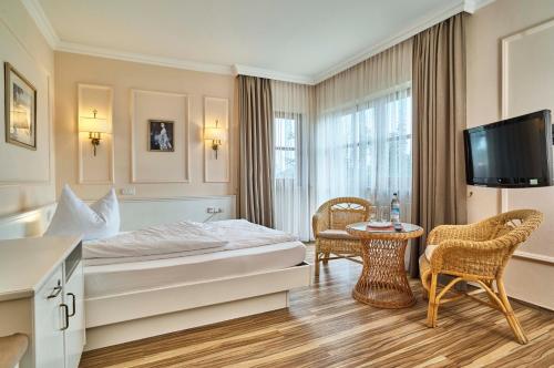 une chambre d'hôtel avec un lit, une table et des chaises dans l'établissement Hotel Lindenhof, à Kellberg