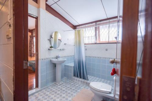 a bathroom with a toilet and a sink at Dunah's Garden Home in Bangkok
