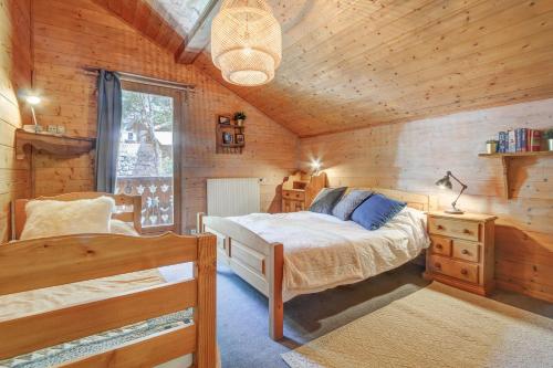 une chambre avec un lit dans une cabane en bois dans l'établissement CHALET L'GORZON, à Morzine