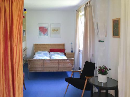 een slaapkamer met een bed, een tafel en een stoel bij Haus am Hagen in Friedland