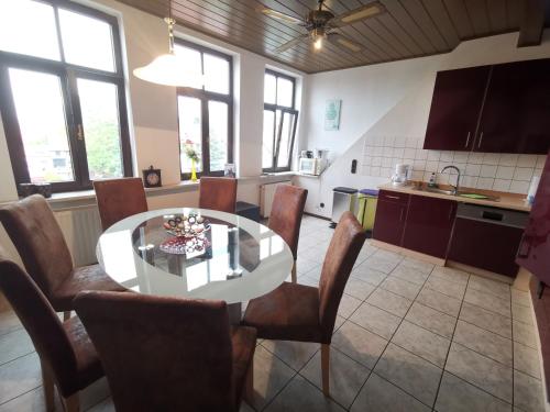 eine Küche und ein Esszimmer mit Tisch und Stühlen in der Unterkunft Ferienwohnungen Bergstrasse in Wernigerode