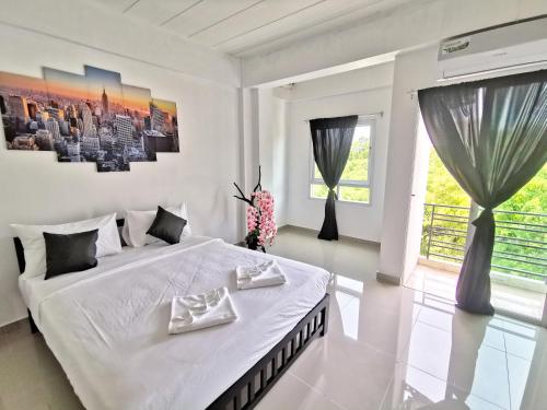 a white bedroom with a large bed with two dishes on it at Thai Orange Villas in Jomtien Beach