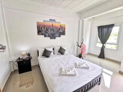 a white bedroom with a bed with two white towels on it at Thai Orange Villas - Private Pool Villas - Modern & Privacy in Jomtien Beach