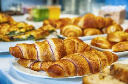 a table topped with plates of croissants and pastries at Hotel Parco Fola in Albinea