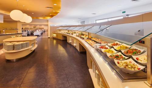 a buffet line with many plates of food at Hipotels Mediterraneo Club in Sa Coma