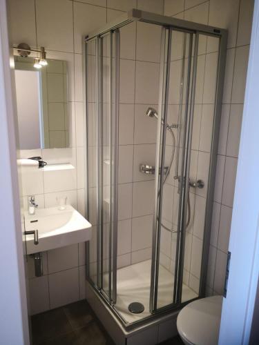 a bathroom with a glass shower and a sink at Weisses Rössli in Leukerbad