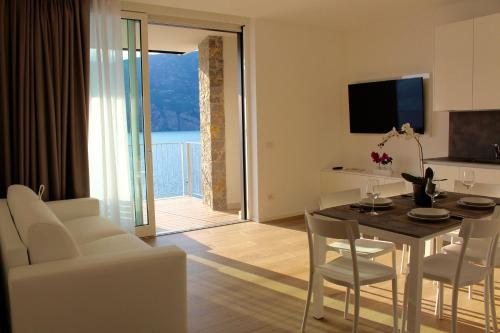 a living room with a table and chairs and a television at My Lake Apartments in Malcesine