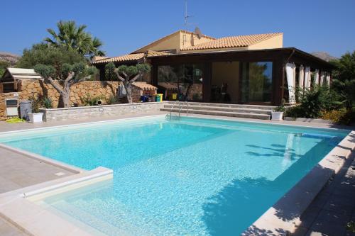 a large swimming pool in front of a house at Villa Antares in Custonaci