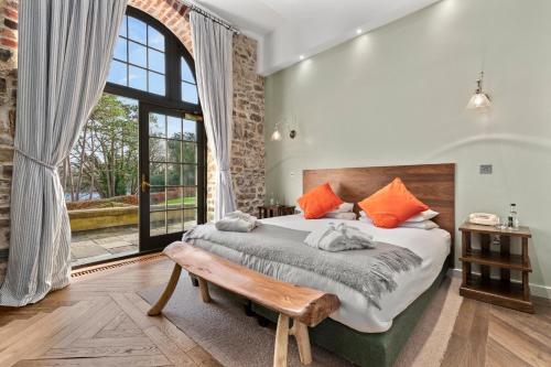 a bedroom with a bed with a bench and a window at Slebech Park Estate in Wiston