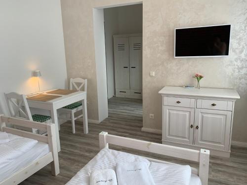 a room with a bed and a desk and a tv at Haus 8 in Lübeck