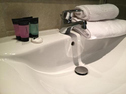 - un lavabo blanc dans la salle de bains avec un rouleau de papier toilette dans l'établissement Bosquet 1, à Canillo