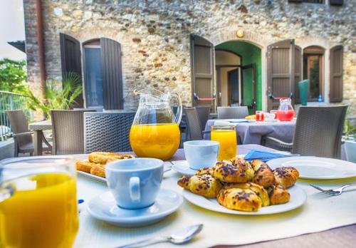 uma mesa com pratos de comida e sumo de laranja em Hotel Parco Fola em Albinea
