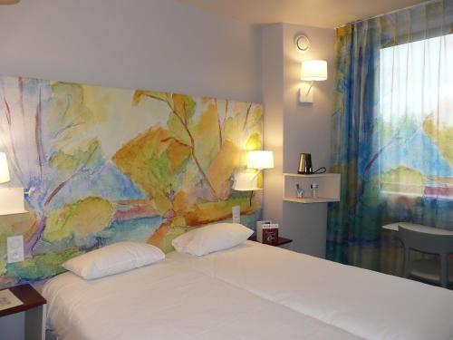 Ένα ή περισσότερα κρεβάτια σε δωμάτιο στο Brit Hotel Codalysa Marne la Vallée - Torcy