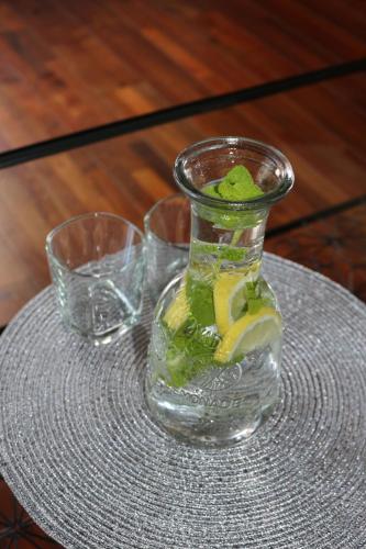 a glass vase on a table with two glasses at Apartament STUDIO i Apartament ZADOMEK Spytkowice koło ZATORA in Spytkowice