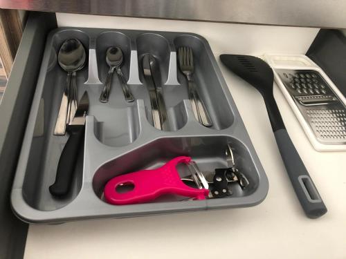 a tray with cutlery and utensils sitting on a table at Safe Move - 23 Lancaster House in Leicester