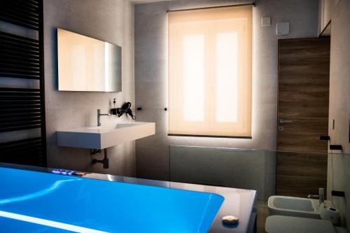 ein Badezimmer mit einer blauen Badewanne und einem Waschbecken in der Unterkunft Sea Front House - Tono Milazzo in Milazzo