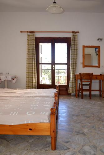 a bedroom with a bed and a table and a window at Rania in Kokkari